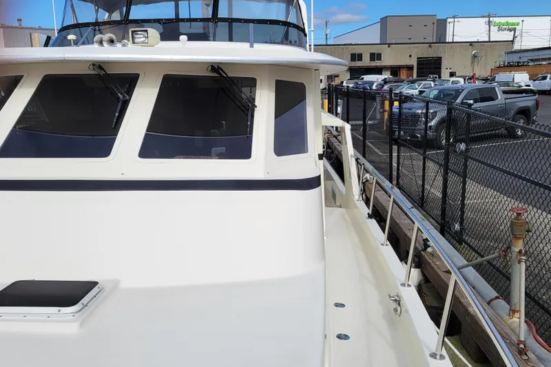 Slide: The Image of 1998 Tollycraft 65 Pilothouse yacht docked, showcasing sleek design and spacious deck. - 12