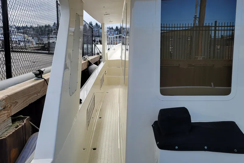 Slide: The Image of 1998 Tollycraft 65 Pilothouse yacht deck with railing and window view. - 14