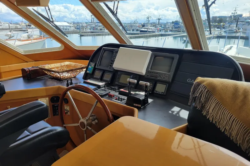 Slide: The Image of Pilothouse interior of 1998 Tollycraft 65, featuring navigation equipment and marina view. - 19
