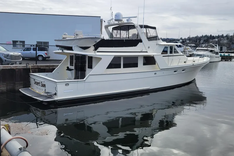 Slide: The Image of 1998 Tollycraft 65 Pilothouse yacht docked in a marina, reflecting on calm water. - 2