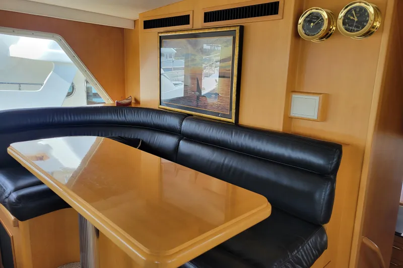 Slide: The Image of Luxurious interior of 1998 Tollycraft 65 Pilothouse with black leather seating and wooden table. - 21