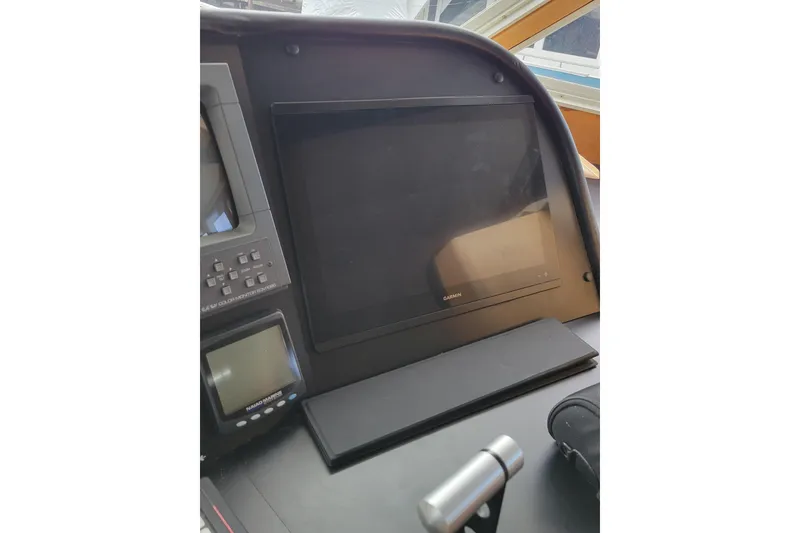 Slide: The Image of 1998 Tollycraft 65 Pilothouse helm with Garmin navigation display and controls. - 24