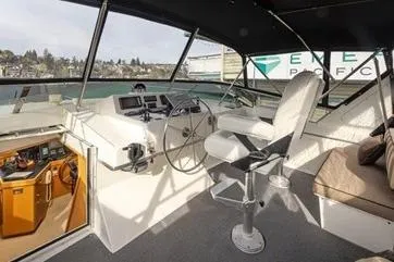Slide: The Image of 1998 Tollycraft 65 Pilothouse interior with helm, seating, and panoramic windows. - 27