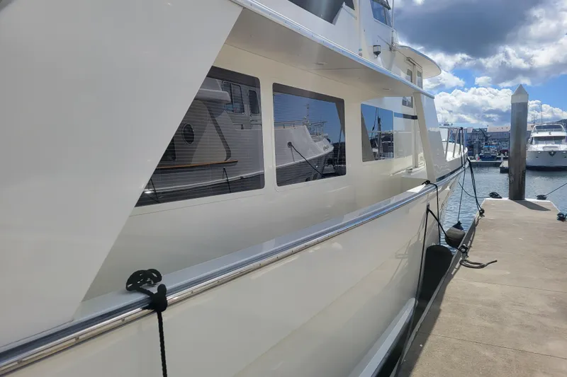 Slide: The Image of 1998 Tollycraft 65 Pilothouse yacht docked at marina under cloudy sky. - 3