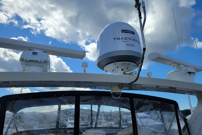 Slide: The Image of 1998 Tollycraft 65 Pilothouse with TracVision satellite system under a cloudy sky. - 31