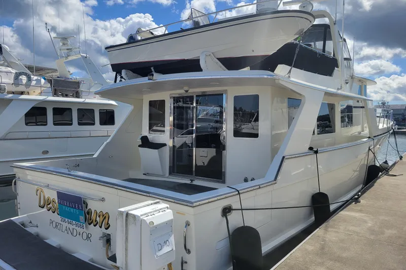 Slide: The Image of 1998 Tollycraft 65 Pilothouse yacht docked in a marina under a partly cloudy sky. - 4