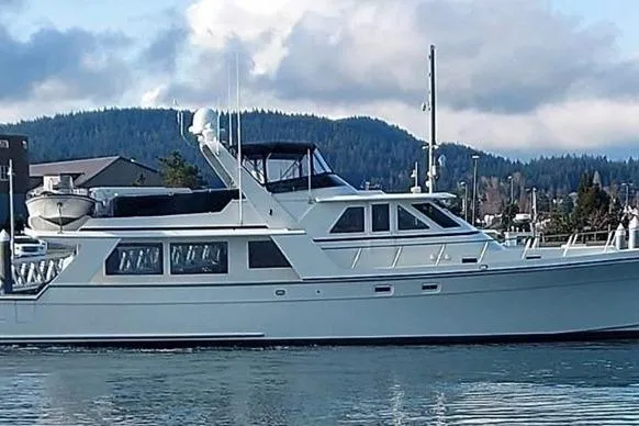 Slide: The Image of 1998 Tollycraft 65 Pilothouse yacht cruising on a serene waterway with scenic mountain backdrop. - 5