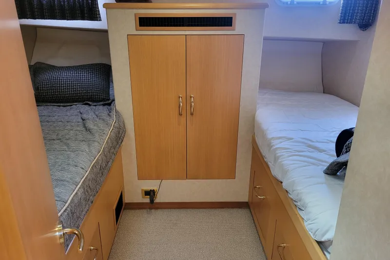 Slide: The Image of 1998 Tollycraft 65 Pilothouse cabin interior with twin beds and wooden cabinetry. - 55