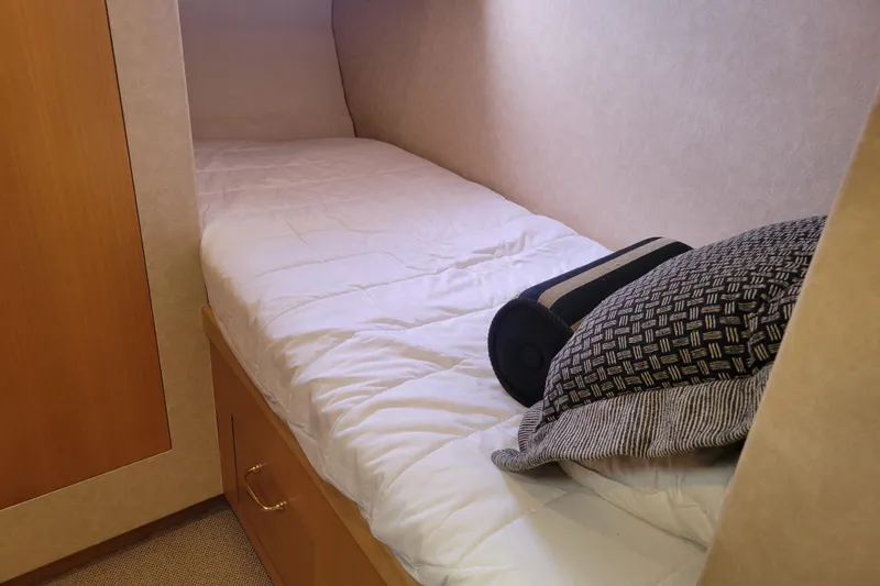 Slide: The Image of Cozy cabin bed in 1998 Tollycraft 65 Pilothouse yacht with pillows and wooden storage. - 56