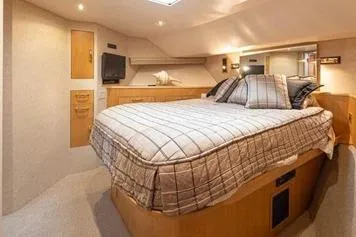 Slide: The Image of Luxurious bedroom interior of 1998 Tollycraft 65 Pilothouse yacht with cozy bedding. - 61