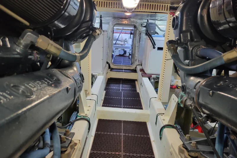 Slide: The Image of Engine room of 1998 Tollycraft 65 Pilothouse yacht, showcasing machinery and walkway. - 64