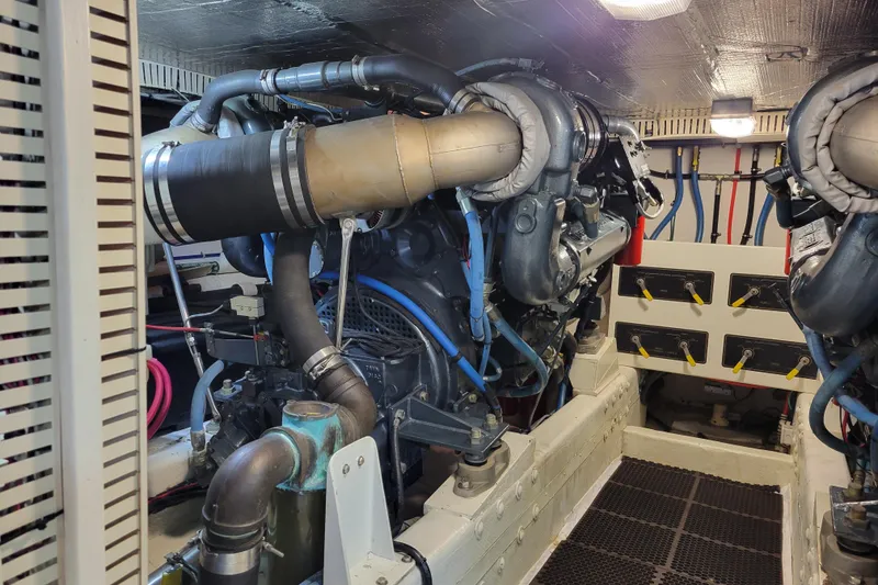 Slide: The Image of Engine room of a 1998 Tollycraft 65 Pilothouse yacht, showcasing complex machinery and piping. - 69