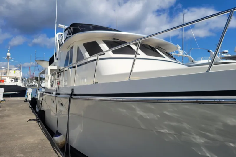 Slide: The Image of 1998 Tollycraft 65 Pilothouse yacht docked under a clear blue sky. - 7