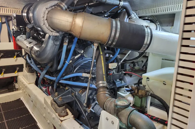 Slide: The Image of Engine room of a 1998 Tollycraft 65 Pilothouse yacht, showcasing complex machinery and piping. - 71