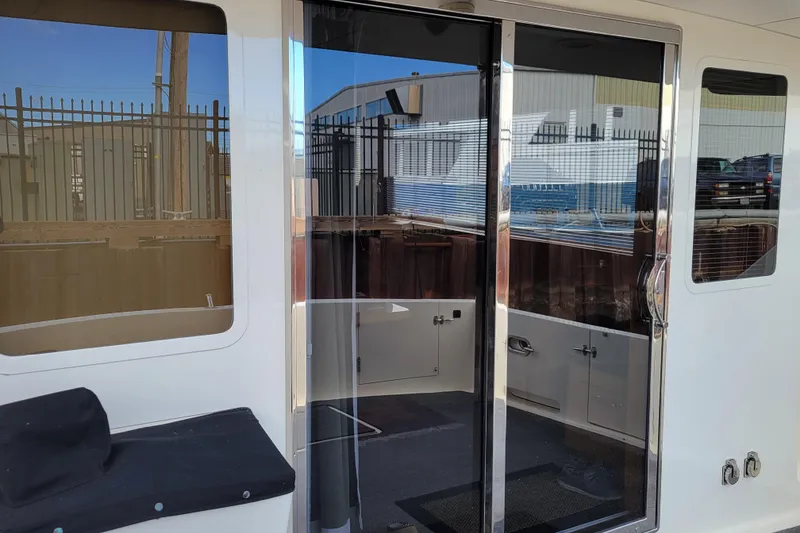 Slide: The Image of 1998 Tollycraft 65 Pilothouse yacht with sliding glass doors and outdoor seating area. - 8