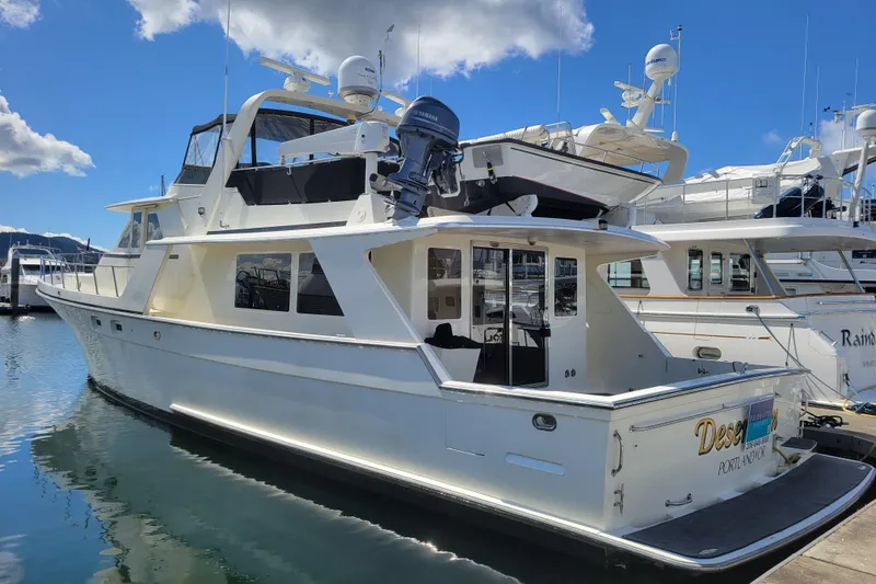 Slide: The Image of 1998 Tollycraft 65 Pilothouse yacht docked in a marina under a blue sky. - 80