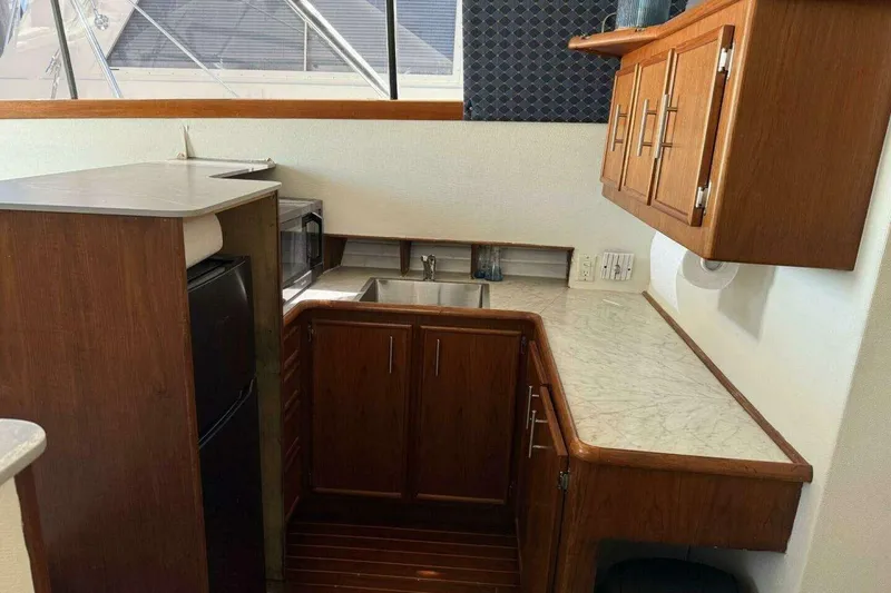 Slide: The Image of 1988 Ocean Yachts 35 Super Sport galley with wood cabinetry, marble countertops, and modern appliances. - 11
