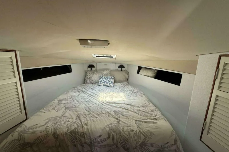 Slide: The Image of Cozy cabin interior of 1988 Ocean Yachts 35 Super Sport with bed and decorative pillows. - 13