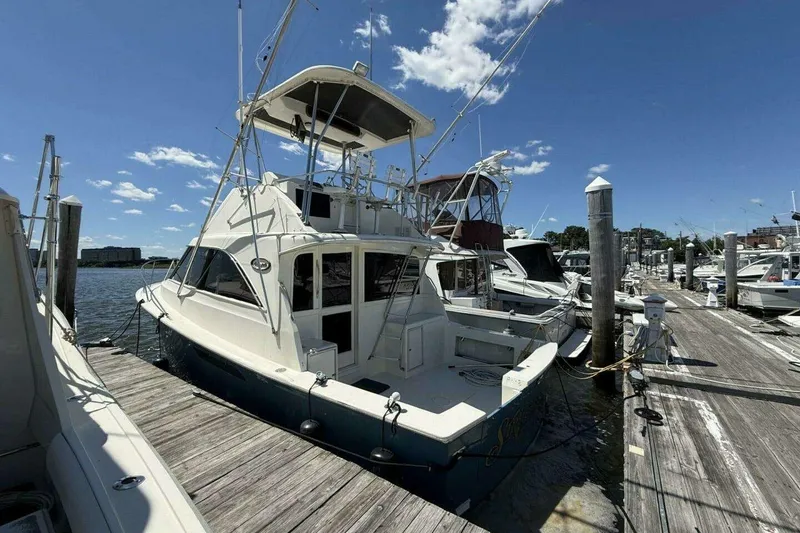 Slide: The Image of 1988 Ocean Yachts 35 Super Sport docked at marina under clear blue sky. - 2