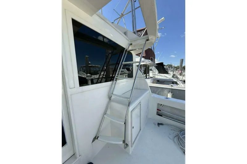Slide: The Image of 1988 Ocean Yachts 35 Super Sport boat deck with ladder and marina view. - 4
