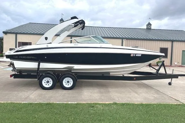 The Image of 2014 Regal 27 FasDeck boat on trailer, parked outdoors. - 0