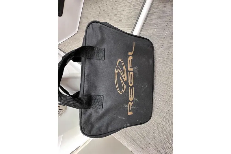 Slide: The Image of Black Regal branded bag on a textured surface, associated with 2014 Regal 27 FasDeck. - 27
