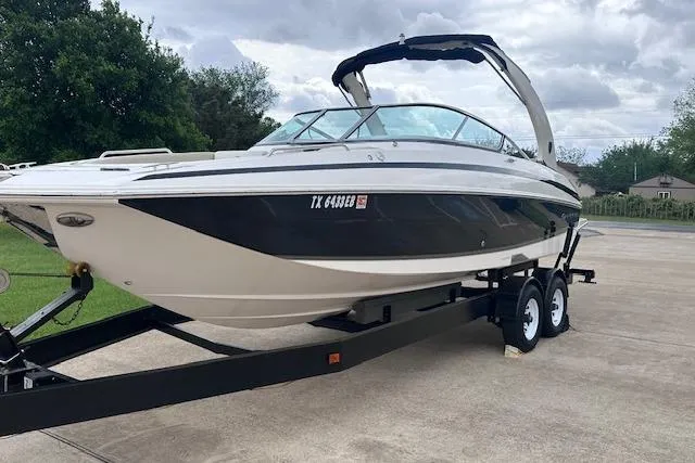 Slide: The Image of 2014 Regal 27 FasDeck boat on trailer, parked outdoors under cloudy sky. - 3