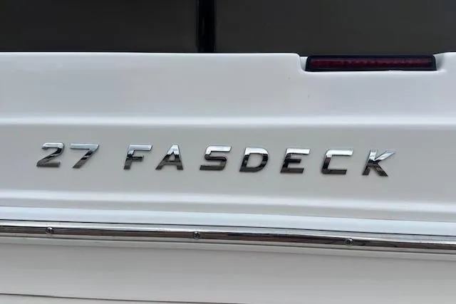Slide: The Image of 2014 Regal 27 FasDeck boat emblem on white surface. - 30