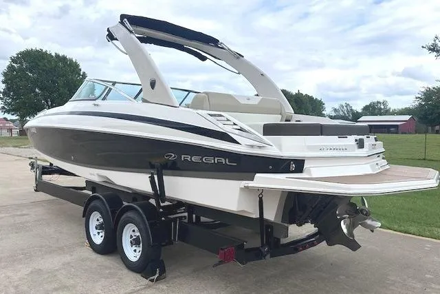 Slide: The Image of 2014 Regal 27 FasDeck boat on trailer, sleek design, parked outdoors. - 4
