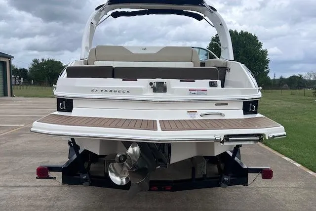 Slide: The Image of 2014 Regal 27 FasDeck boat, rear view, showcasing swim platform and dual propellers. - 6
