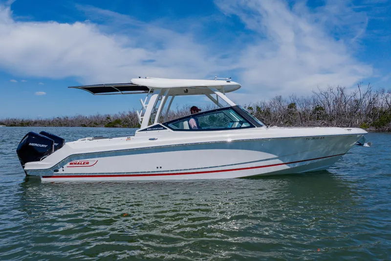 Slide: The Image of 2021 Boston Whaler 280 Vantage boat on calm water under a clear blue sky. - 11