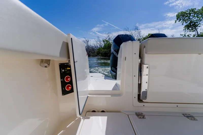 Slide: The Image of 2021 Boston Whaler 280 Vantage boat interior with open hatch and dual engines. - 24