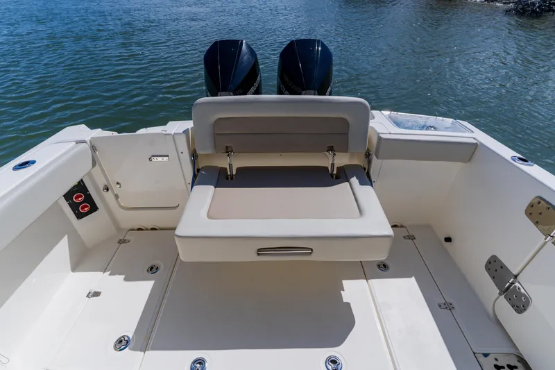 Slide: The Image of 2021 Boston Whaler 280 Vantage boat interior with seating and dual engines on water. - 28