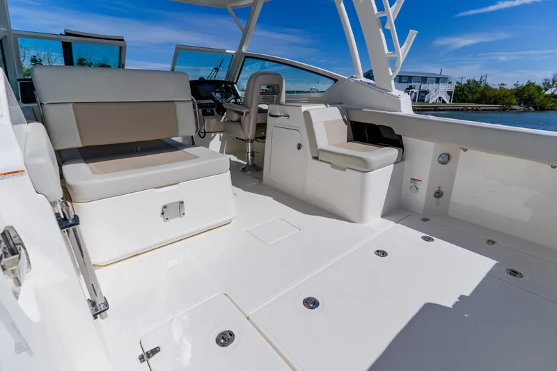 Slide: The Image of 2021 Boston Whaler 280 Vantage boat interior with seating and helm, under clear blue sky. - 38