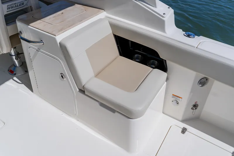 Slide: The Image of 2021 Boston Whaler 280 Vantage boat seating area with storage and cup holders. - 39