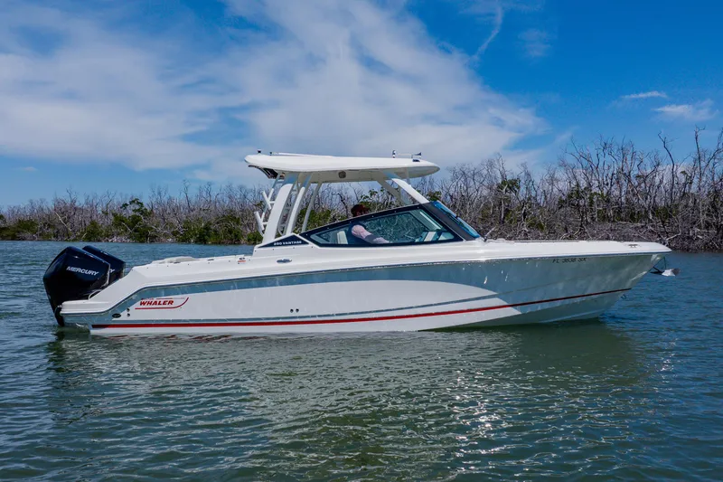 Slide: The Image of 2021 Boston Whaler 280 Vantage boat on calm water under a clear blue sky. - 4