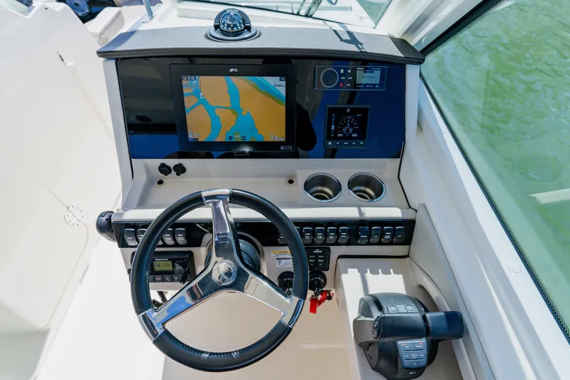 Slide: The Image of 2021 Boston Whaler 280 Vantage helm with navigation display and steering wheel. - 49