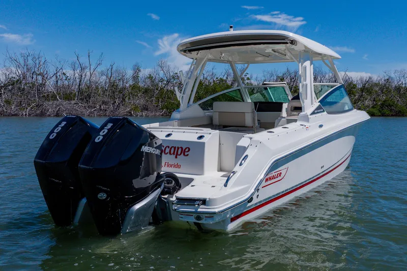 Slide: The Image of 2021 Boston Whaler 280 Vantage boat with dual Mercury engines on calm water. - 5