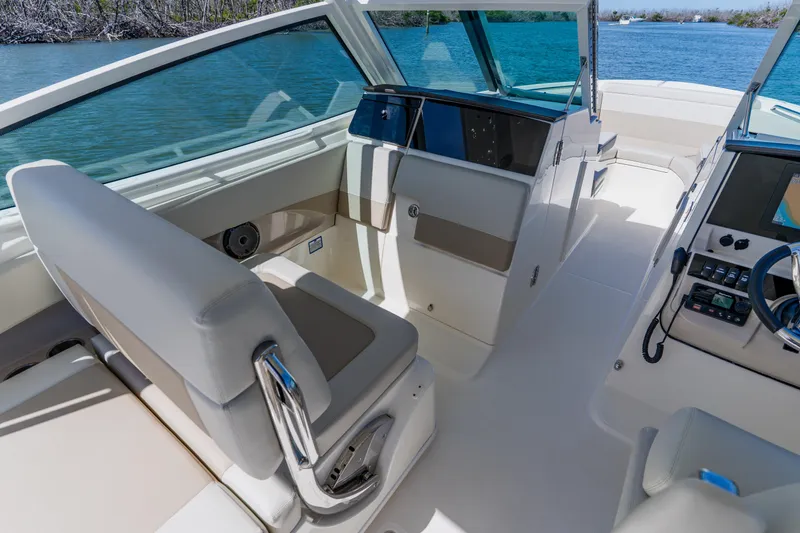 Slide: The Image of 2021 Boston Whaler 280 Vantage interior with helm, seating, and water view. - 53