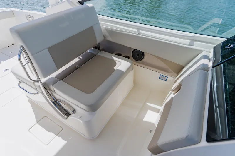 Slide: The Image of 2021 Boston Whaler 280 Vantage interior seating with beige cushions and stainless steel accents. - 55