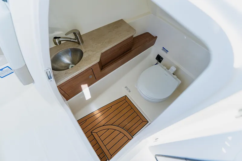 Slide: The Image of 2021 Boston Whaler 280 Vantage boat bathroom with sink, toilet, and wooden floor. - 68