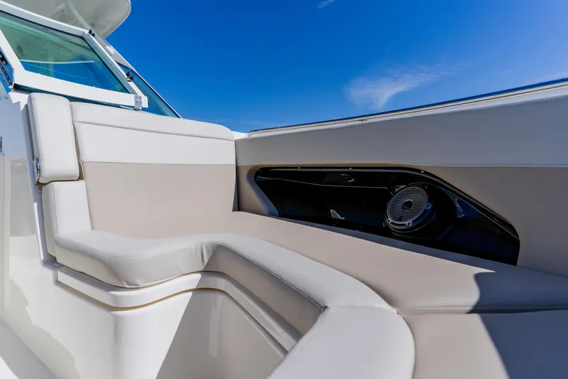 Slide: The Image of 2021 Boston Whaler 280 Vantage boat interior with beige seating under clear blue sky. - 76