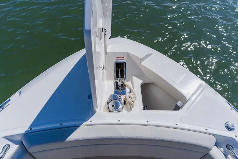 Slide: The Image of Boston Whaler 280 Vantage 2021 bow anchor compartment with open hatch on water. - 79