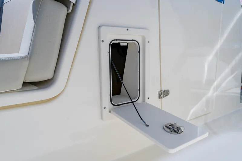 Slide: The Image of 2021 Boston Whaler 280 Vantage storage compartment with open hatch and cable. - 84