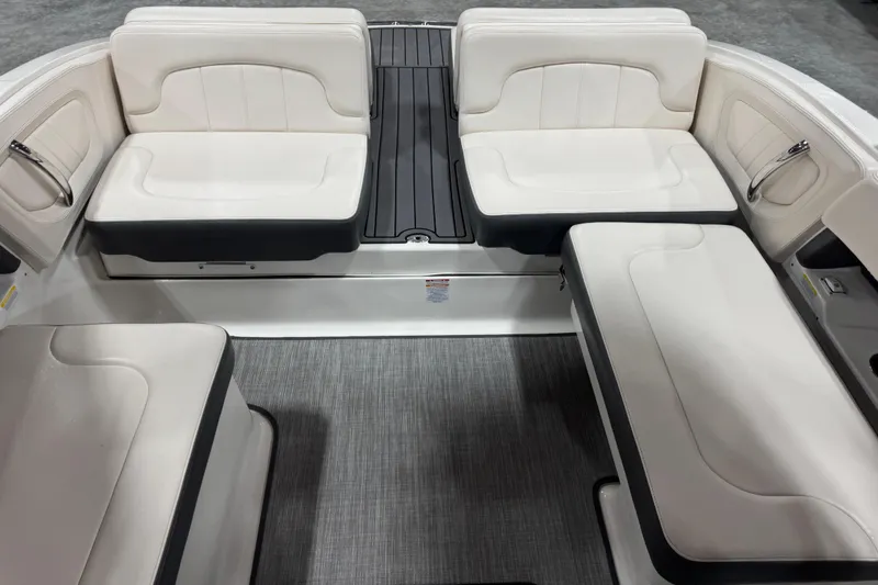 Slide: The Image of 2017 Chaparral 257 SSX boat interior with white cushioned seating and gray flooring. - 10