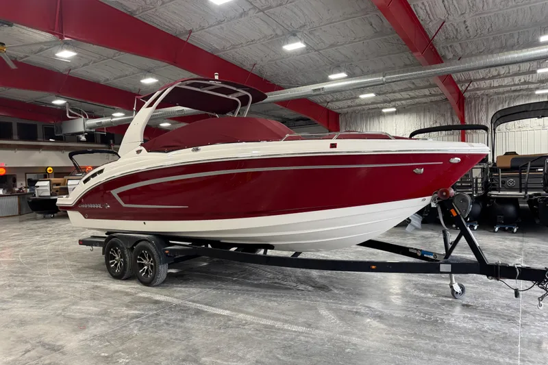 Slide: The Image of 2017 Chaparral 257 SSX boat in a showroom, red and white exterior on a trailer. - 17