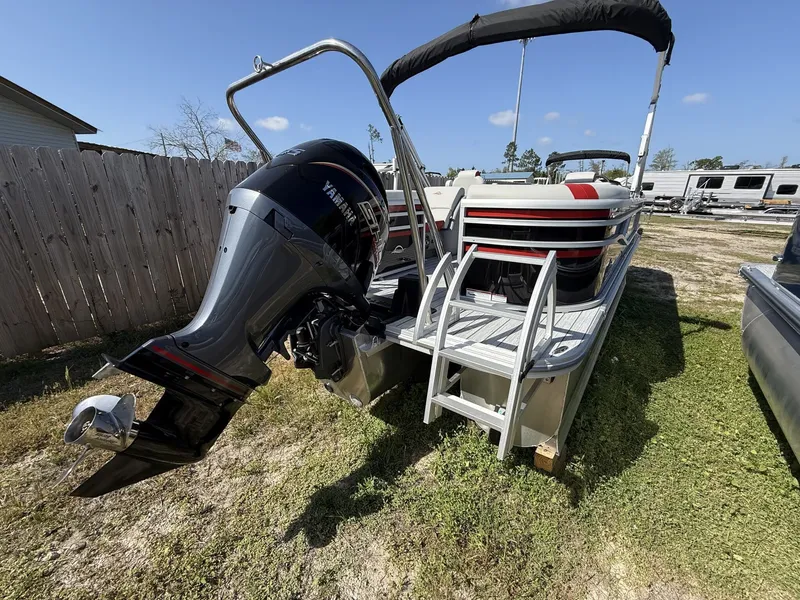 Slide: The Image of 2026 Avalon LSZ 25 Quad Lounger-Tritoon with 200HP engine, parked on grass. - 9