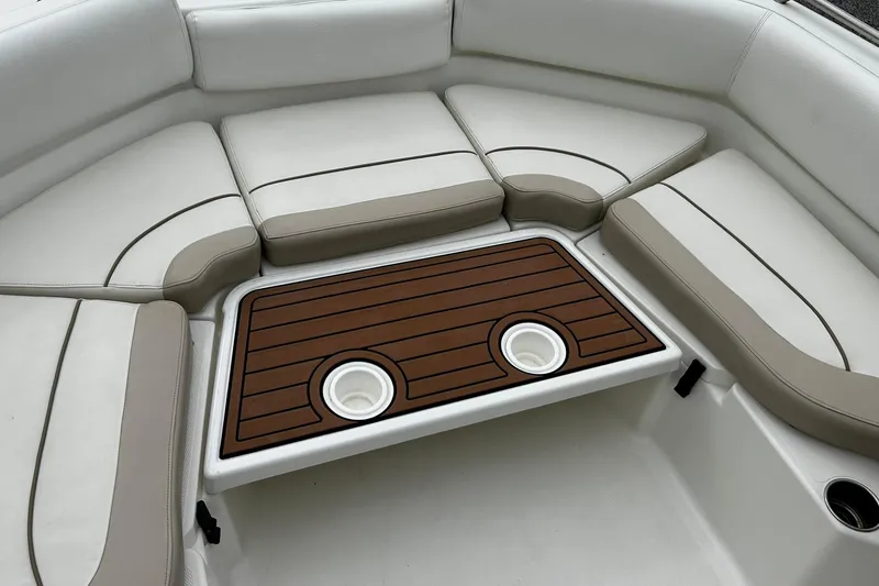 Slide: The Image of 2015 NauticStar 231 Coastal boat interior with cushioned seating and wooden table. - 15