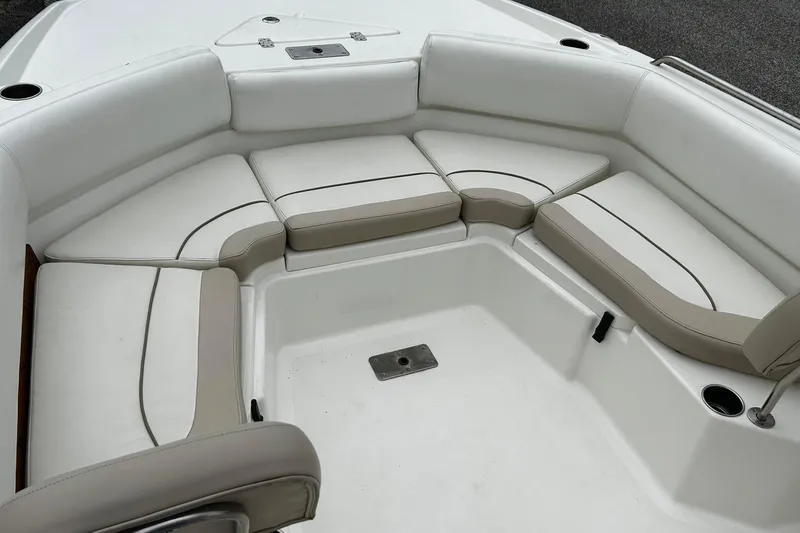 Slide: The Image of 2015 NauticStar 231 Coastal boat interior with cushioned seating and cup holders. - 16
