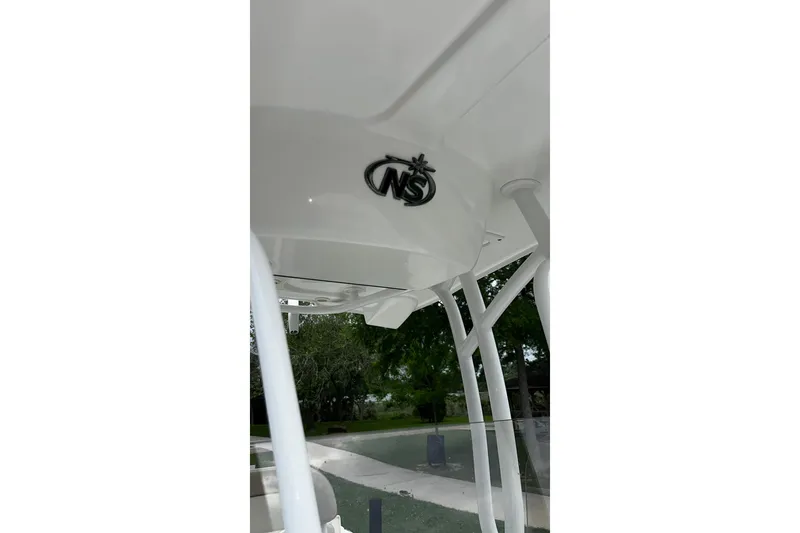 Slide: The Image of 2015 NauticStar 231 Coastal boat with logo, featuring sleek white design and sturdy framework. - 19